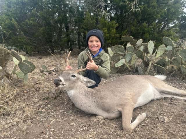 Hunter with a whitetail deer beside prickly pear cactus
