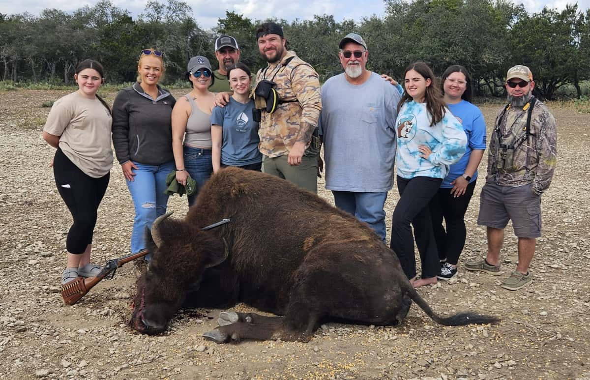 Group gathered behind a harvested bison