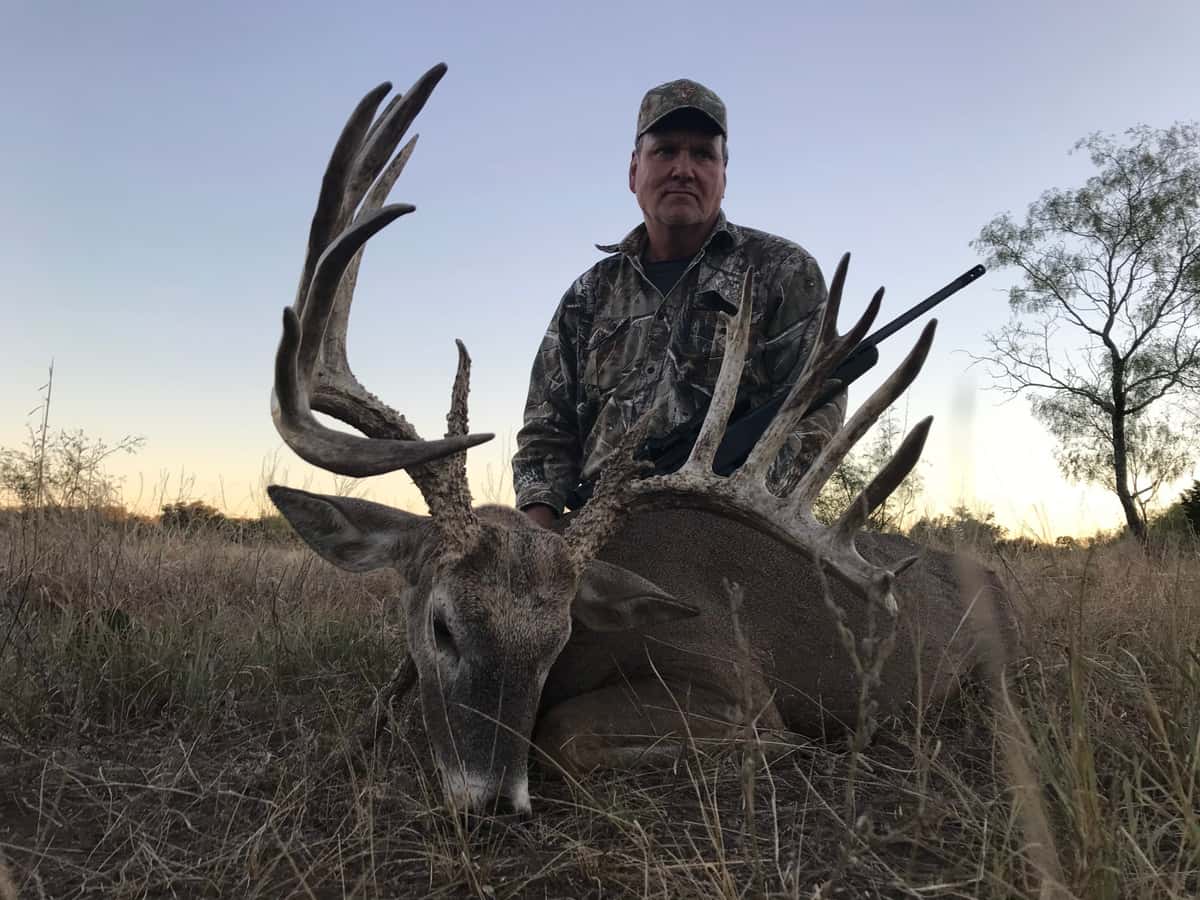 Hunter with a documented 200-inch Whitetail buck at FF Hunting Ranch