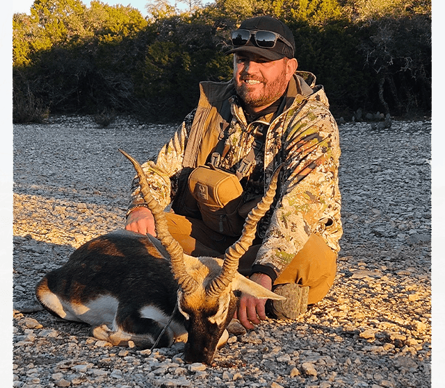 Hunter with a blackbuck antelope in evening sunlight