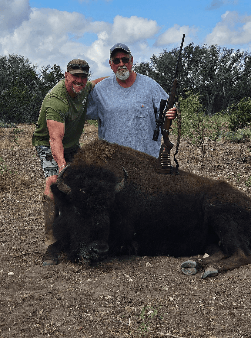 Two hunters with a harvested bison