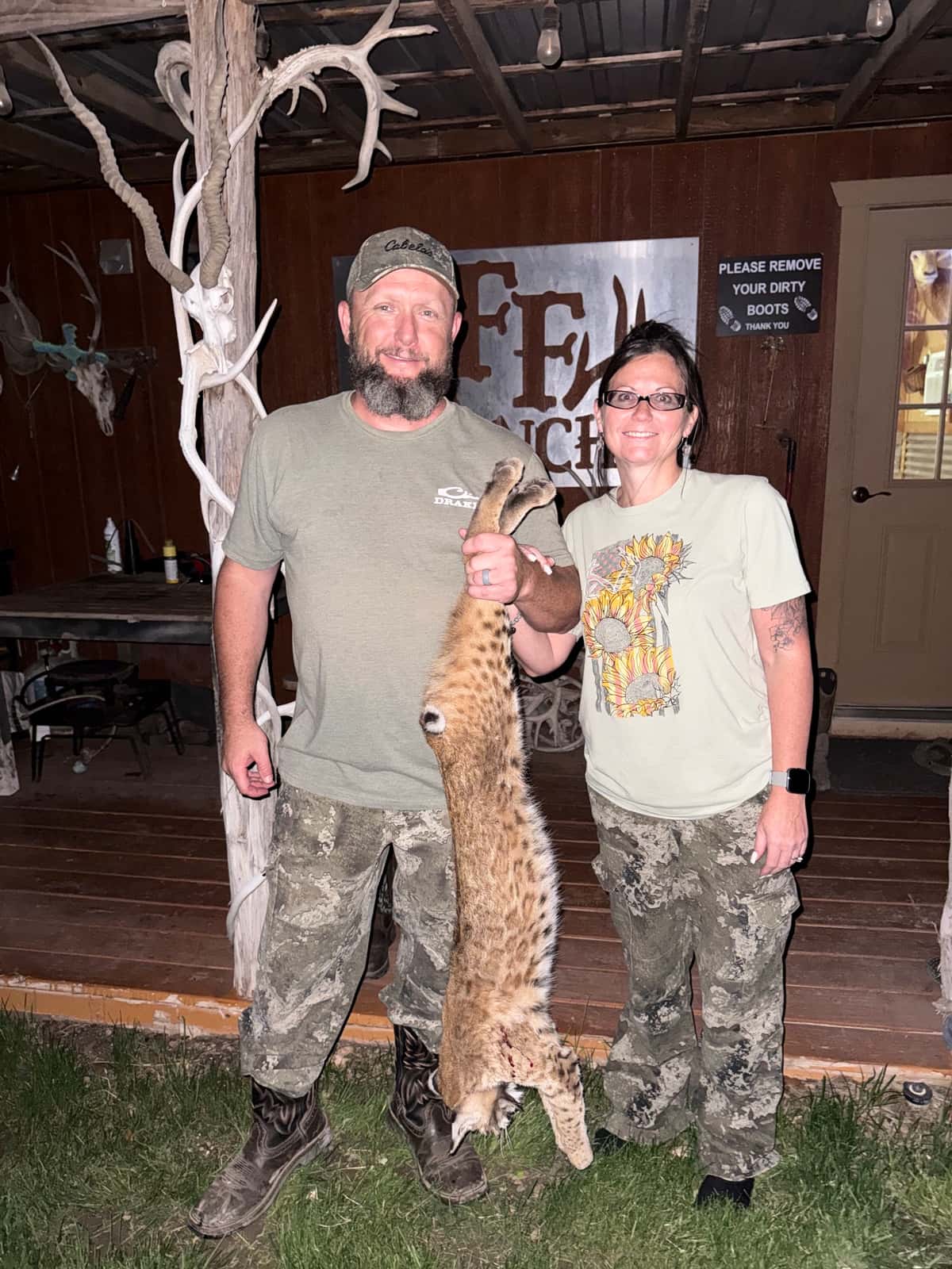 Hunters with a bobcat outside the FF Hunting Ranch camp