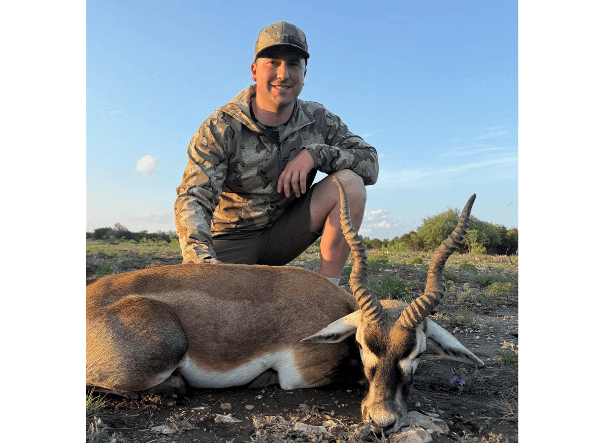 Hunter with a blackbuck antelope in evening sunlight