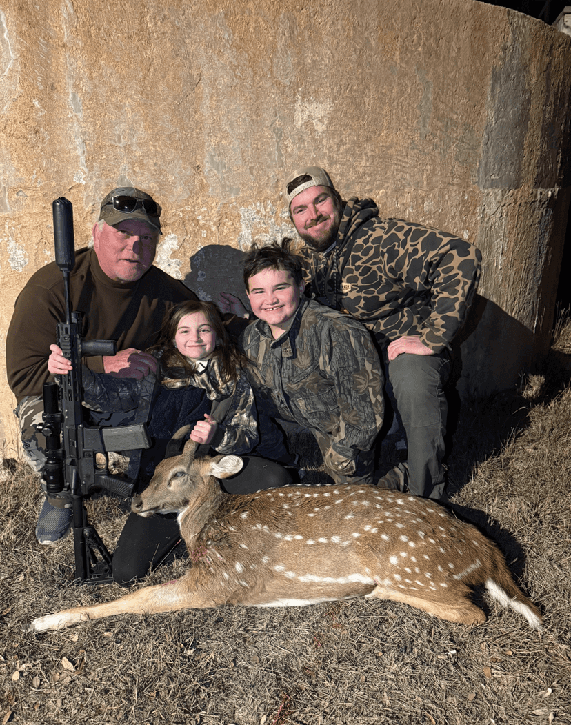 Group posing with an Axis deer beside a round tank