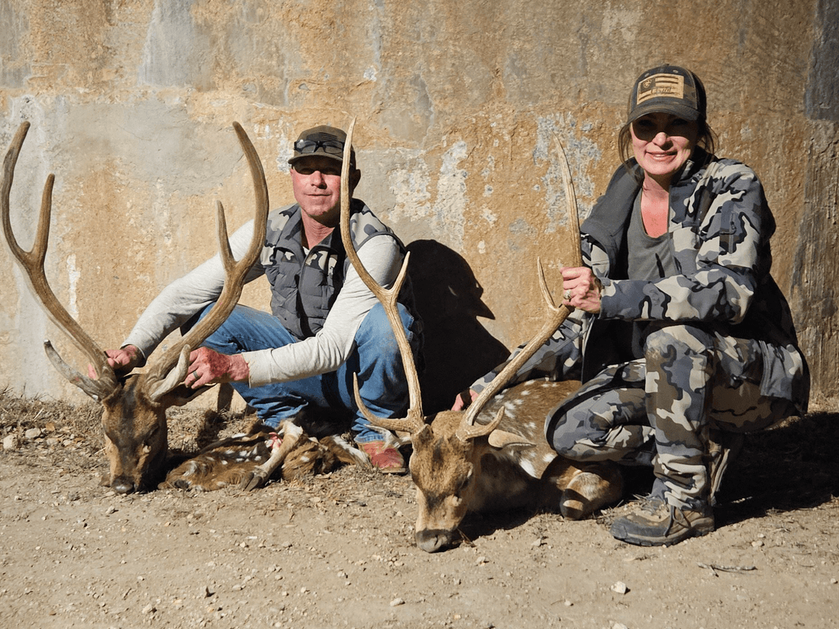 Two hunters with Axis bucks beside a round tank